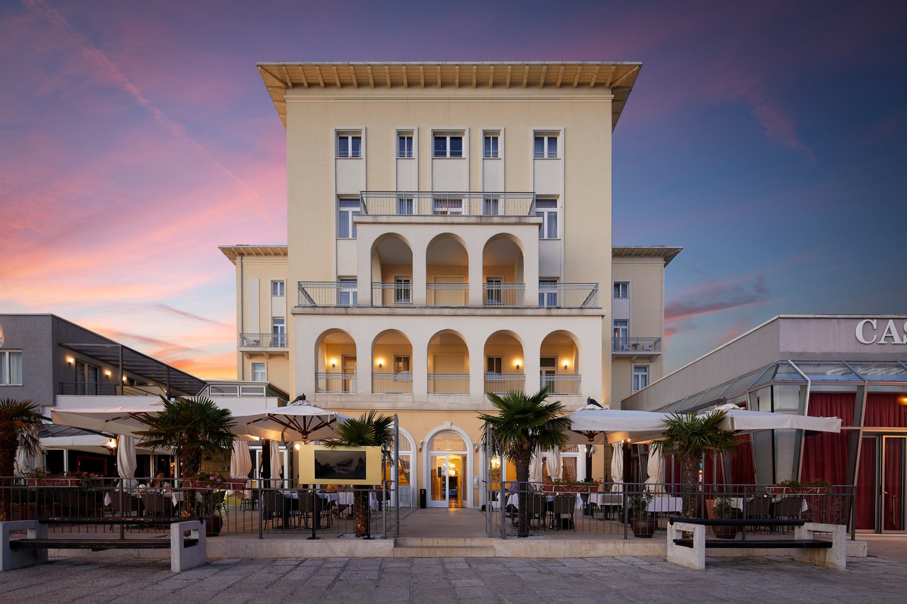 Die im italienischen Renaissance-Stil gehaltene Fassade des BO Hotel Palazzo in der Abenddämmerung.
